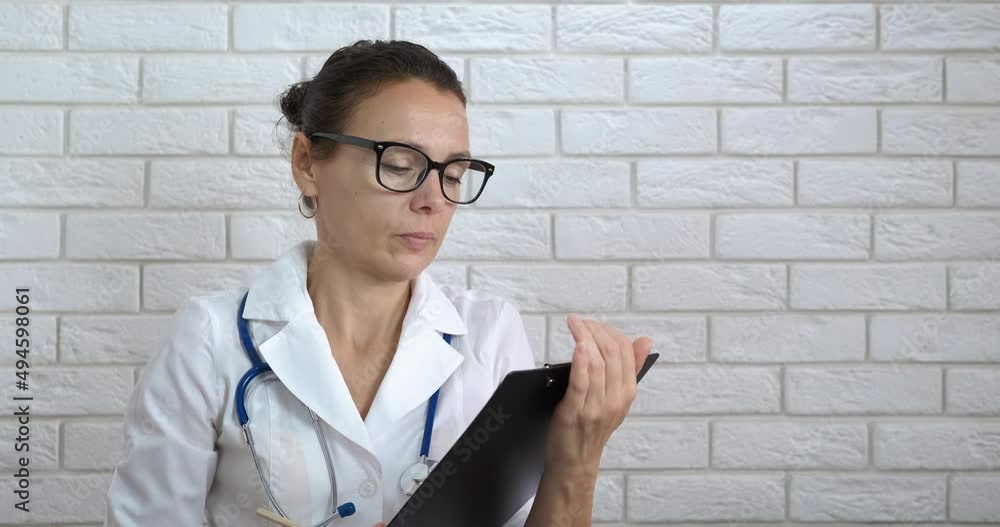 Medic consultation on documents. A female doctor hold her medical consultation on papers in the room. Medic consultation on documents. A female doctor hold her medical consultation on papers in the room.