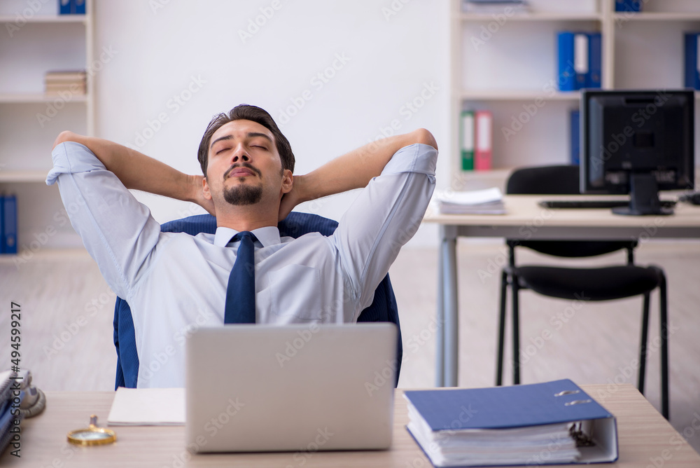 Young male employee working in the office Young male employee working in the office