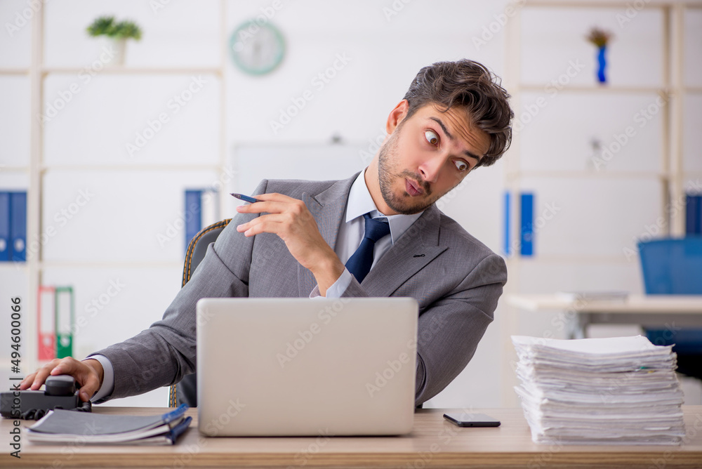 Young male employee sitting at workplace Young male employee sitting at workplace