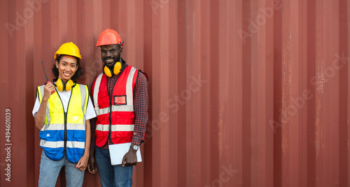 Two African american male and female worker smiling with confidence and success at workplace of industrial container warehouse.