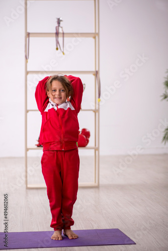 Young little girl doing sport exercises at home