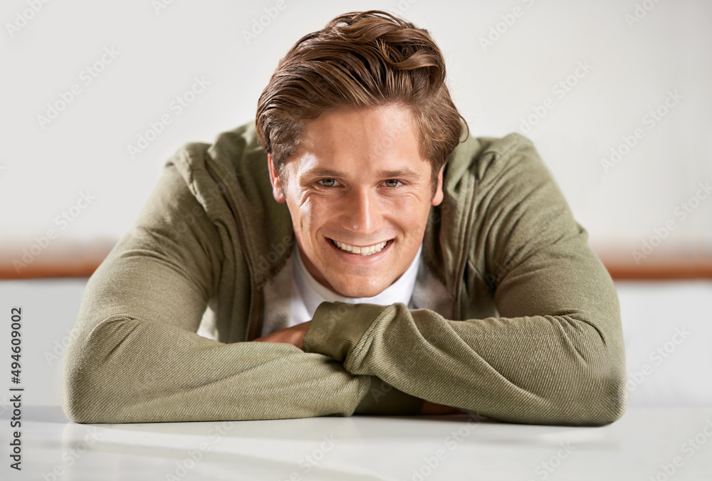 Fototapeta premium His smile just pulls you in.... A young man leaning on his arms and smiling at the camera.