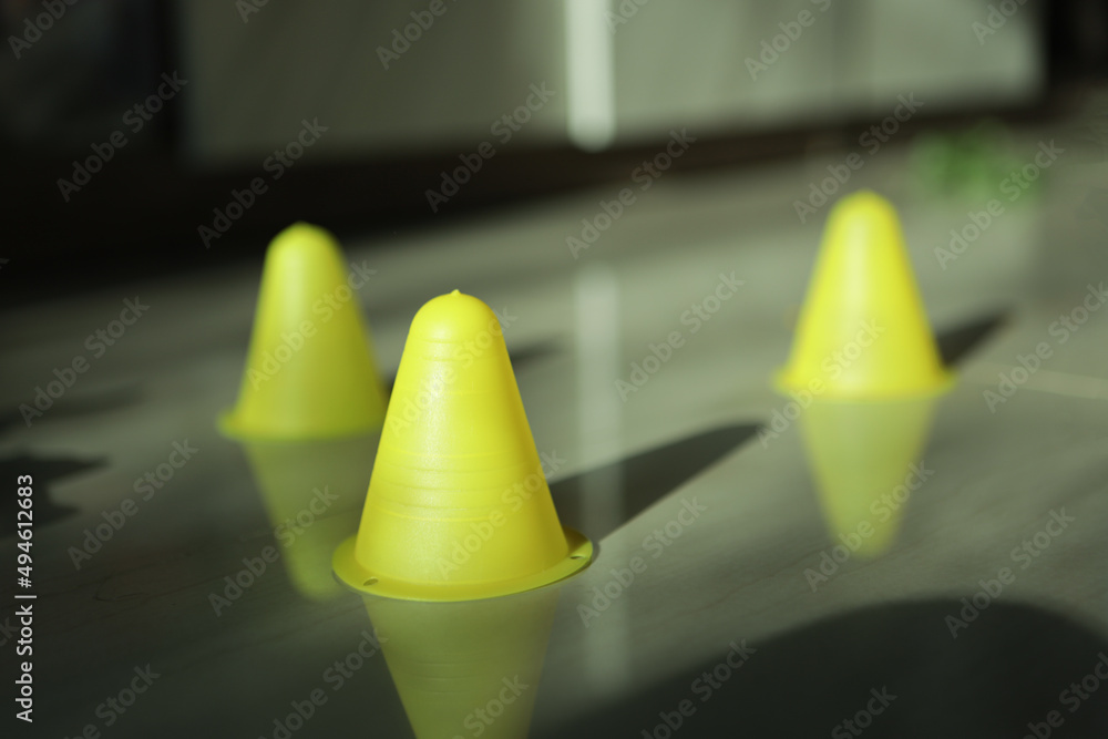 A small yellow cone is lying on the ground. A small yellow cone is lying on the ground.