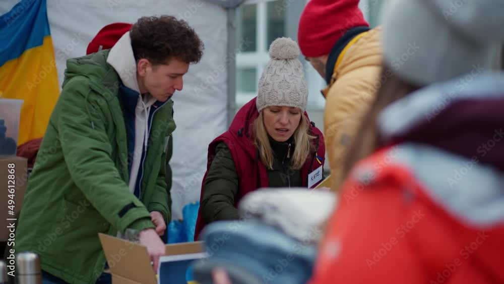 Volunteers distributing food and drink to refugees on the Ukrainian border, humanitarian aid concept. Volunteers distributing food and drink to refugees on the Ukrainian border, humanitarian aid concept.