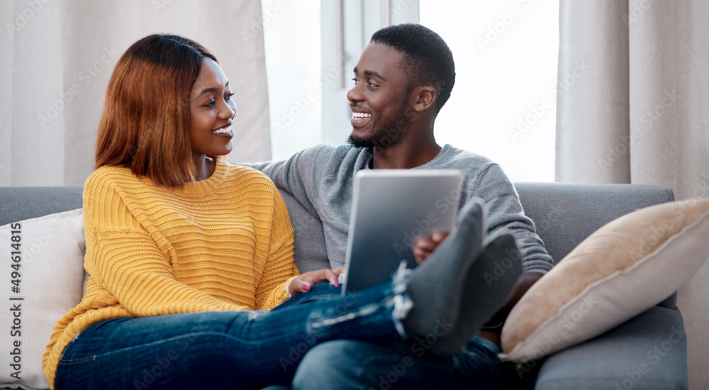 Now everyone knows our relationship status. Shot of a young couple using a digital tablet while relaxing at home. Now everyone knows our relationship status. Shot of a young couple using a digital tablet while relaxing at home.