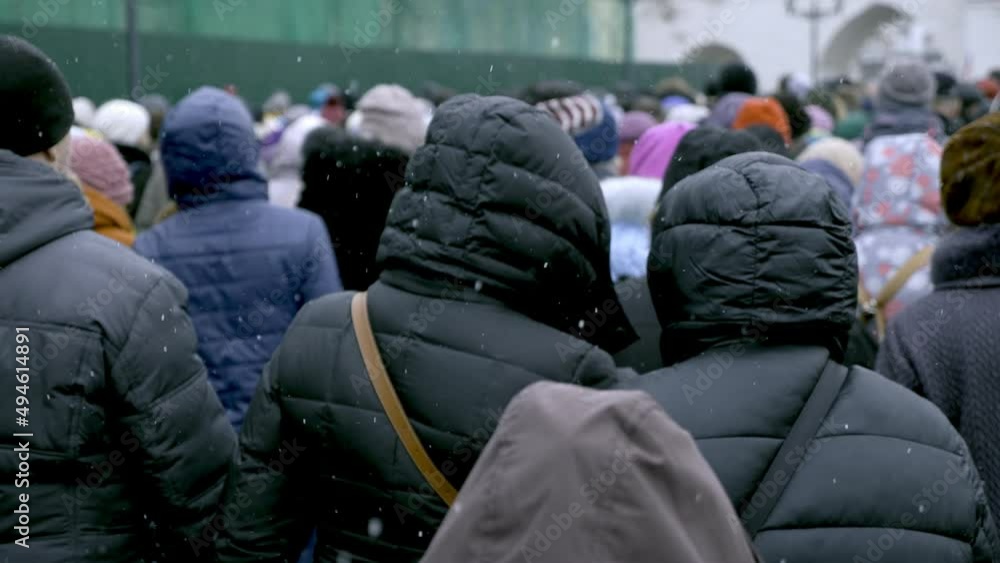 A crowd of migrants is walking along a city street. A crowd of migrants is walking along a city street.