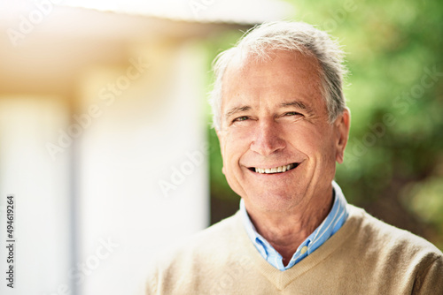 Enjoying his golden years. Portrait of a happy senior man standing outside.