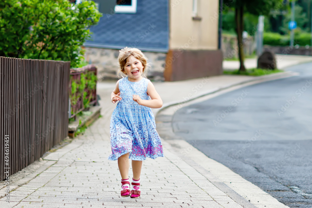 Φωτογραφία Happy little toddler girl running on street in the city, outdoors