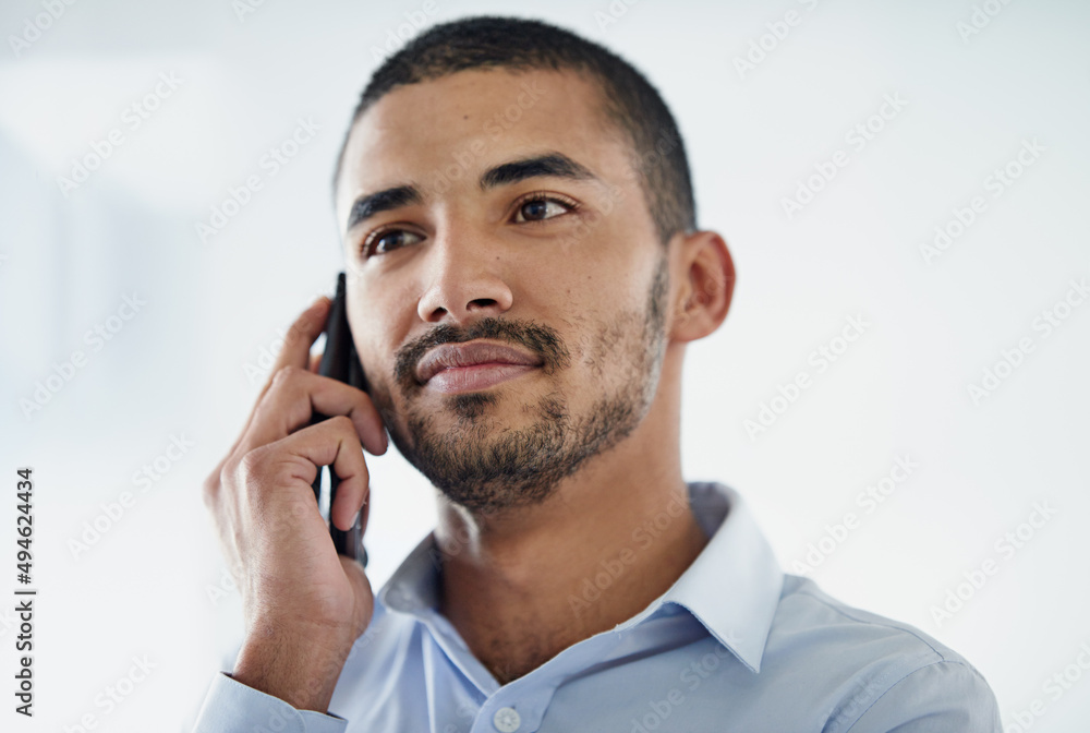 Making contacts. Cropped shot of a handsome young businessman using in cellphone in the office. Making contacts. Cropped shot of a handsome young businessman using in cellphone in the office.