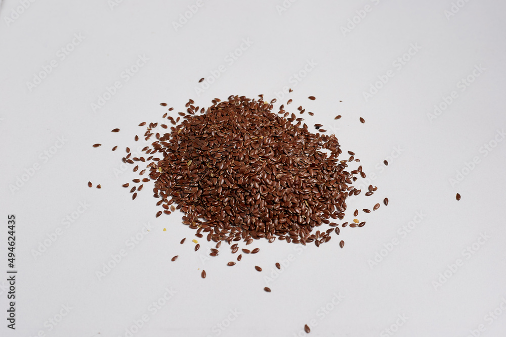 A bunch of flax seeds on a white background, very useful seeds for cooking A bunch of flax seeds on a white background, very useful seeds for cooking