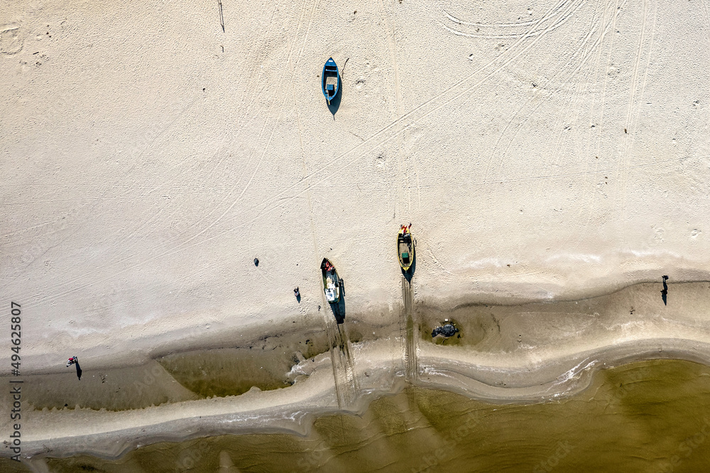 Morze Bałtyckie, widok z lotu ptaka z drona lecącego nad pustą, piękną plażą. Drobne fale rozbijające się o piaszczystą plażę. - obrazy, fototapety, plakaty 