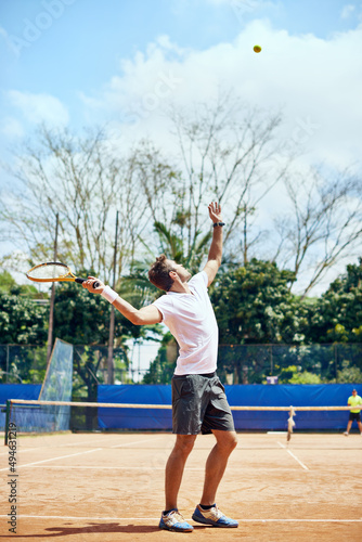 The serve. Shot of a tennis player serving. © Marius V/peopleimages.com
