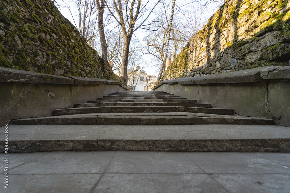 old concrete stairs towards the top along the edges of the stone walls with moss