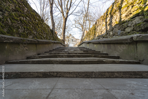 old concrete stairs towards the top along the edges of the stone walls with moss