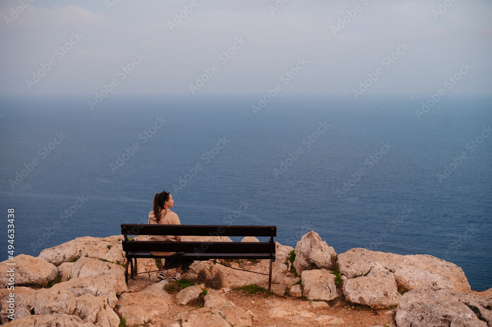 Back view of woman enjoying beautiful sea view from rock Back view of woman enjoying beautiful sea view from rock