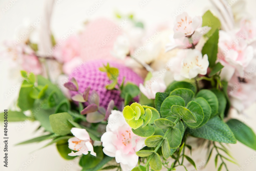Fototapeta premium Spring equinox celebration. Easter theme composition with flowers and crocheted eggs. Featuring bouquets with handmade accents.