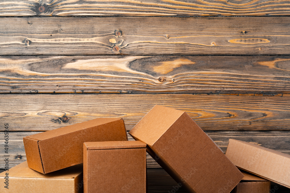 Pile of cardboard boxes on wooden background Pile of cardboard boxes on wooden background