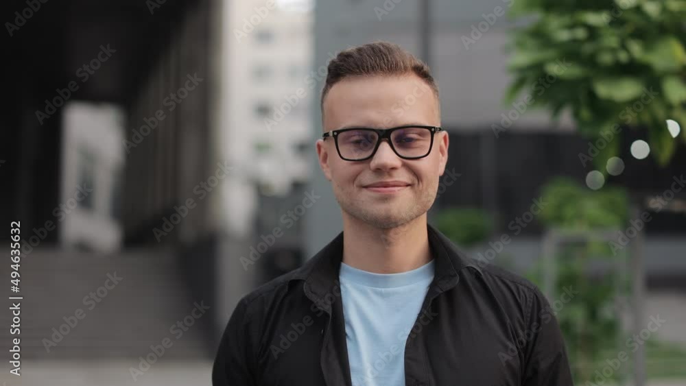 A smiling man is turning his head and looking at the camera. He is wearing glasses. Business center in the background. 4k A smiling man is turning his head and looking at the camera. He is wearing glasses. Business center in the background. 4k