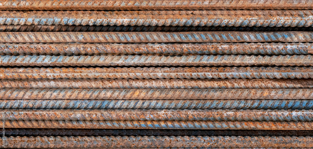 Top view stack of straight old rusty high yield stress deformed reinforcement steel or iron bars.