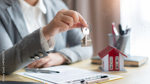 Insurance concept the real estate representative giving a house key to his client after signing the contract
