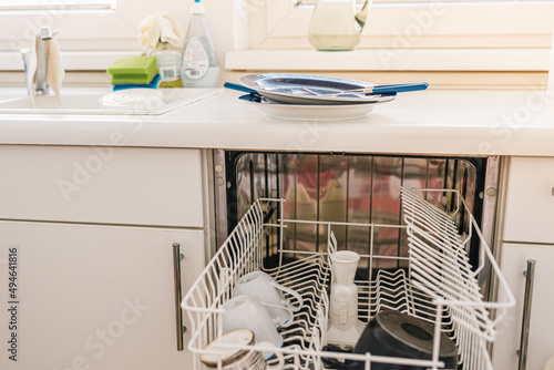 Kitchen with dishwasher, dirty dishes after breakfast. Dishwasher repair, household appliances malfunction