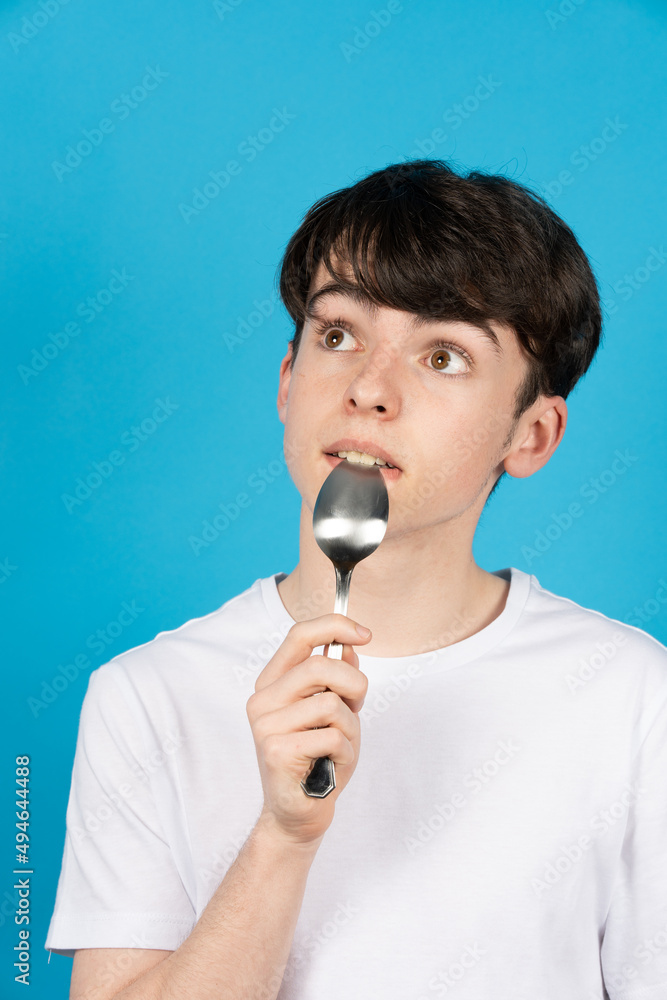 Portrait of cute teenager boy holding a spoon on his mouth. Portrait of cute teenager boy holding a spoon on his mouth.