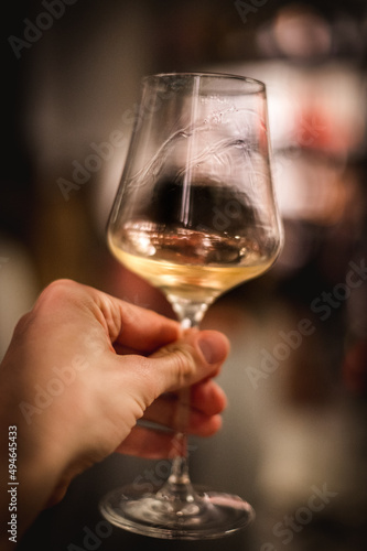 hand with a glass of white wine at a wine tasting
