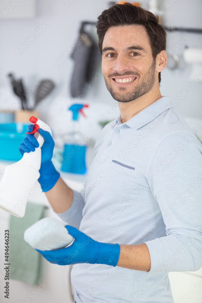 man holds detergent spray and sponge for cleaning home man holds detergent spray and sponge for cleaning home
