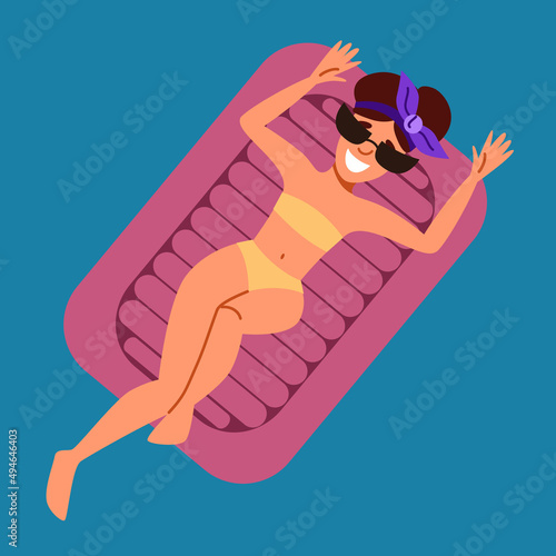 A woman is resting and sunbathing on an inflatable mattress in the sea.