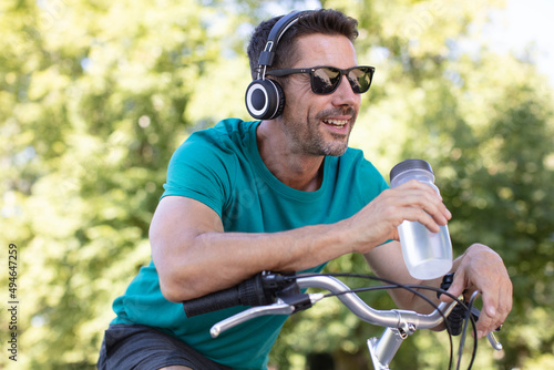 man on a bike drinking water