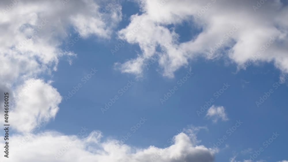 Fluffy white clouds moving across blue sky Fluffy white clouds moving across blue sky