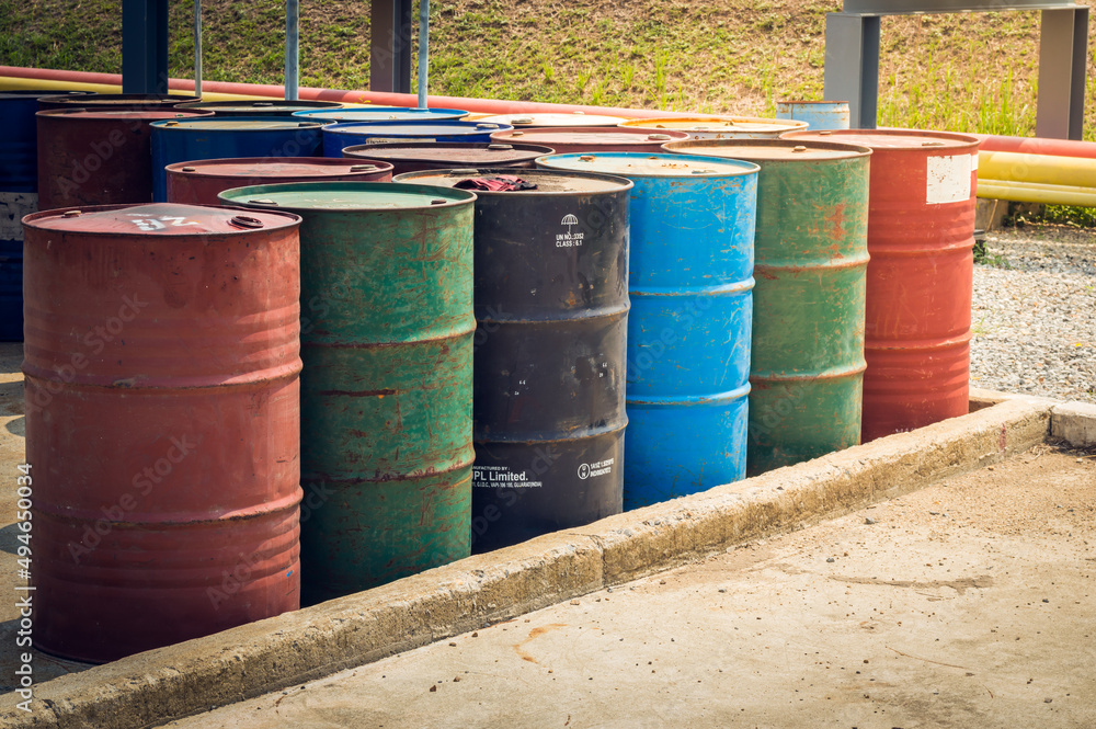 Obraz premium Industry oil barrels or chemical drums stacked up.chemical tank.container of barrels of hydrocarbons.hazardous waste of black and blue tank oil.