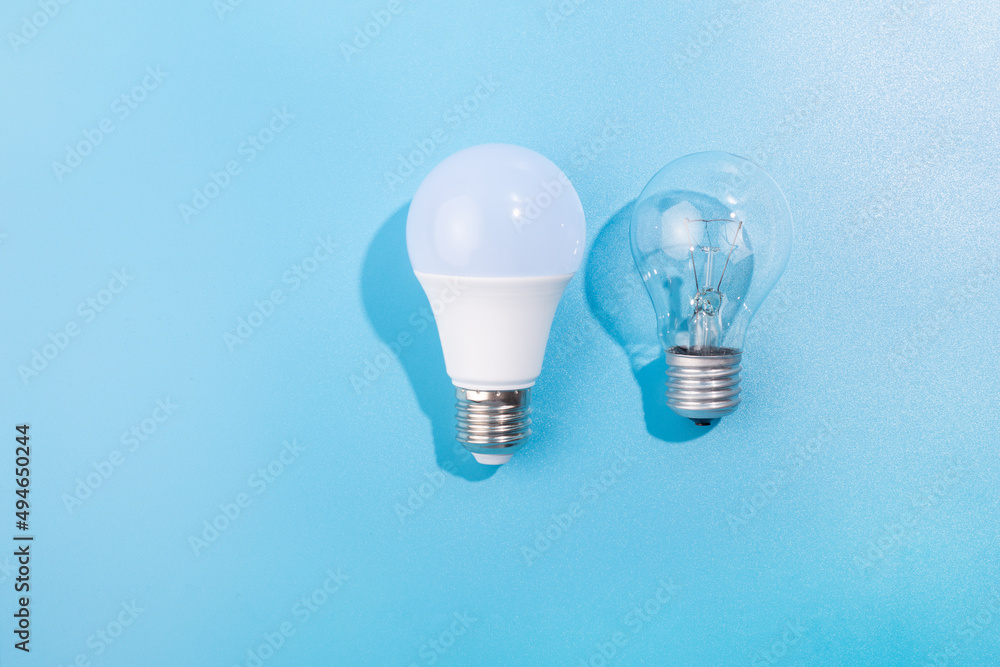 incandescent lamp and led lamp against on isolated blue background. Energy efficiency concept. Flat lay. Concept ecology, save planet earth, idea, save energy, economy, saving. Earth day incandescent lamp and led lamp against on isolated blue background. Energy efficiency concept. Flat lay. Concept ecology, save planet earth, idea, save energy, economy, saving. Earth day