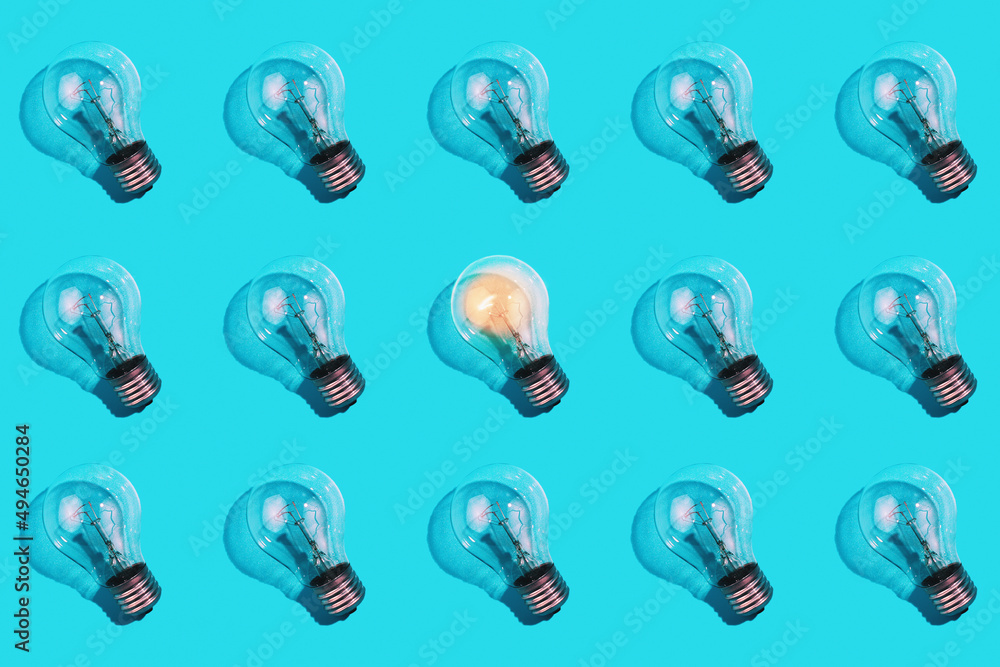 close-up of an incandescent lamp and one glowing lamp on an isolated blue background. The concept of energy efficiency. Flat lay. Concept ecology, saving planet Earth, idea, energy saving, economy. close-up of an incandescent lamp and one glowing lamp on an isolated blue background. The concept of energy efficiency. Flat lay. Concept ecology, saving planet Earth, idea, energy saving, economy.