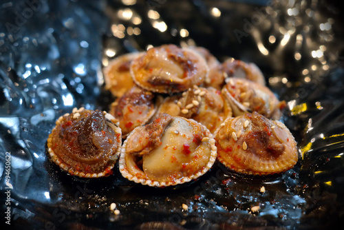 It is a Korean food that is boiled cockles, seasoned with vegetables and red pepper powder, and eaten sweet and sour. photo