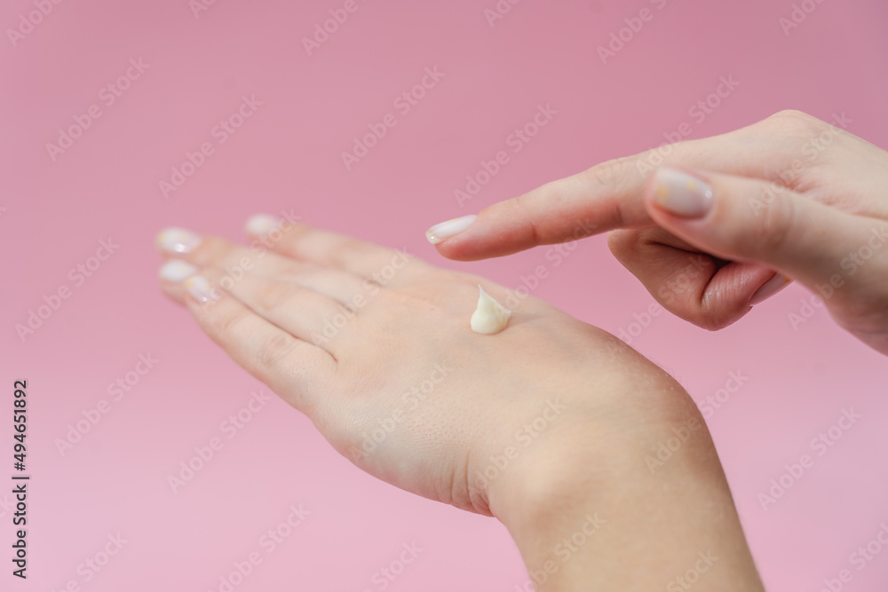 Female hands moisturizer the cream on pink background. Skincare, Spa salon Female hands moisturizer the cream on pink background. Skincare, Spa salon