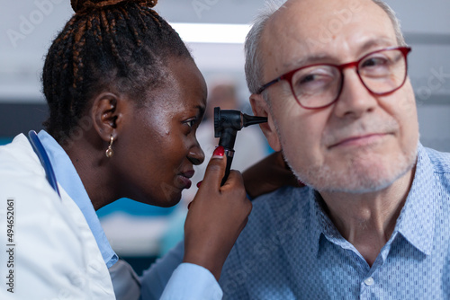 Close up of otology expert examining sick retired person using otoscope to check ear illness. Hospital otology specialist examining ill senior patient internal ear for any disease related symptoms
