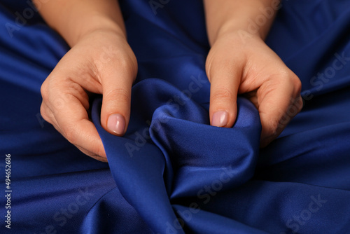 Woman touching silky blue fabric  closeup view