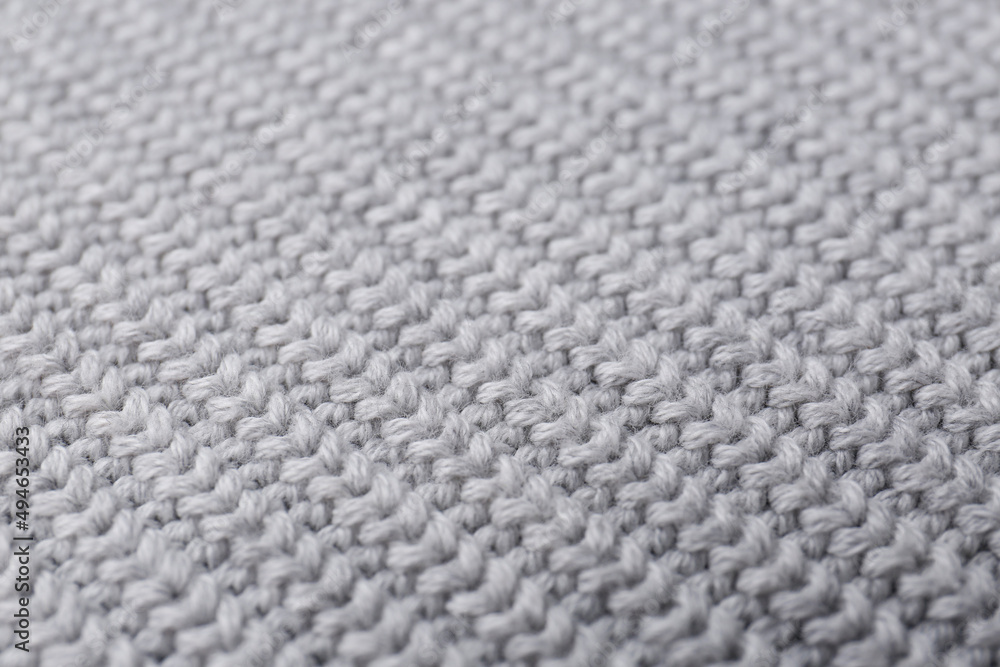 Grey knitted fabric as background, closeup view Grey knitted fabric as background, closeup view
