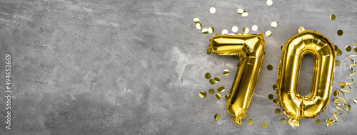 Yellow foil balloon number, number seventy on a concrete background. Greeting card with the inscription 70. Anniversary concept. for anniversary, birthday, new year celebration. banner, photo