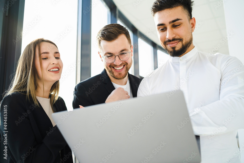 Joyful office workers looking at laptop Joyful office workers looking at laptop