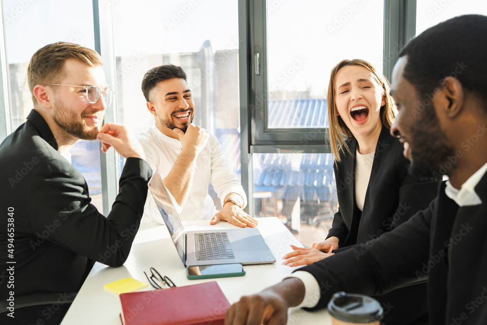 Group of laughing corporation employees at a meeting in the office Group of laughing corporation employees at a meeting in the office