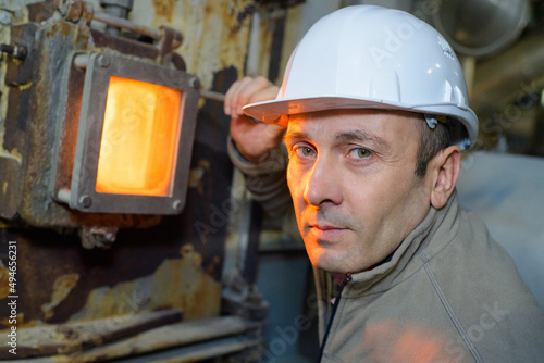 Papier peint portrait of male worker next to incinerator inspection glass