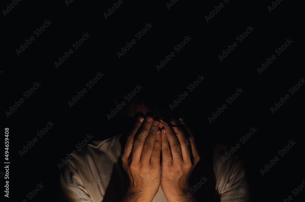 Asian miserable depressed man sitting alone in dark background. Depression and mental health concept. Asian miserable depressed man sitting alone in dark background. Depression and mental health concept.