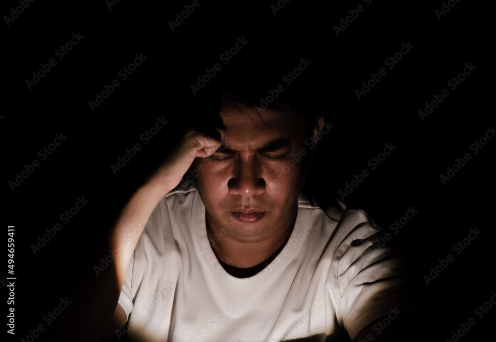 Asian miserable depressed man sitting alone in dark background. Depression and mental health concept. Asian miserable depressed man sitting alone in dark background. Depression and mental health concept.