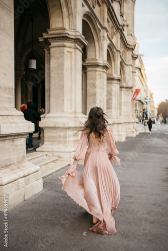 Back view of a pretty young girl in dress running.