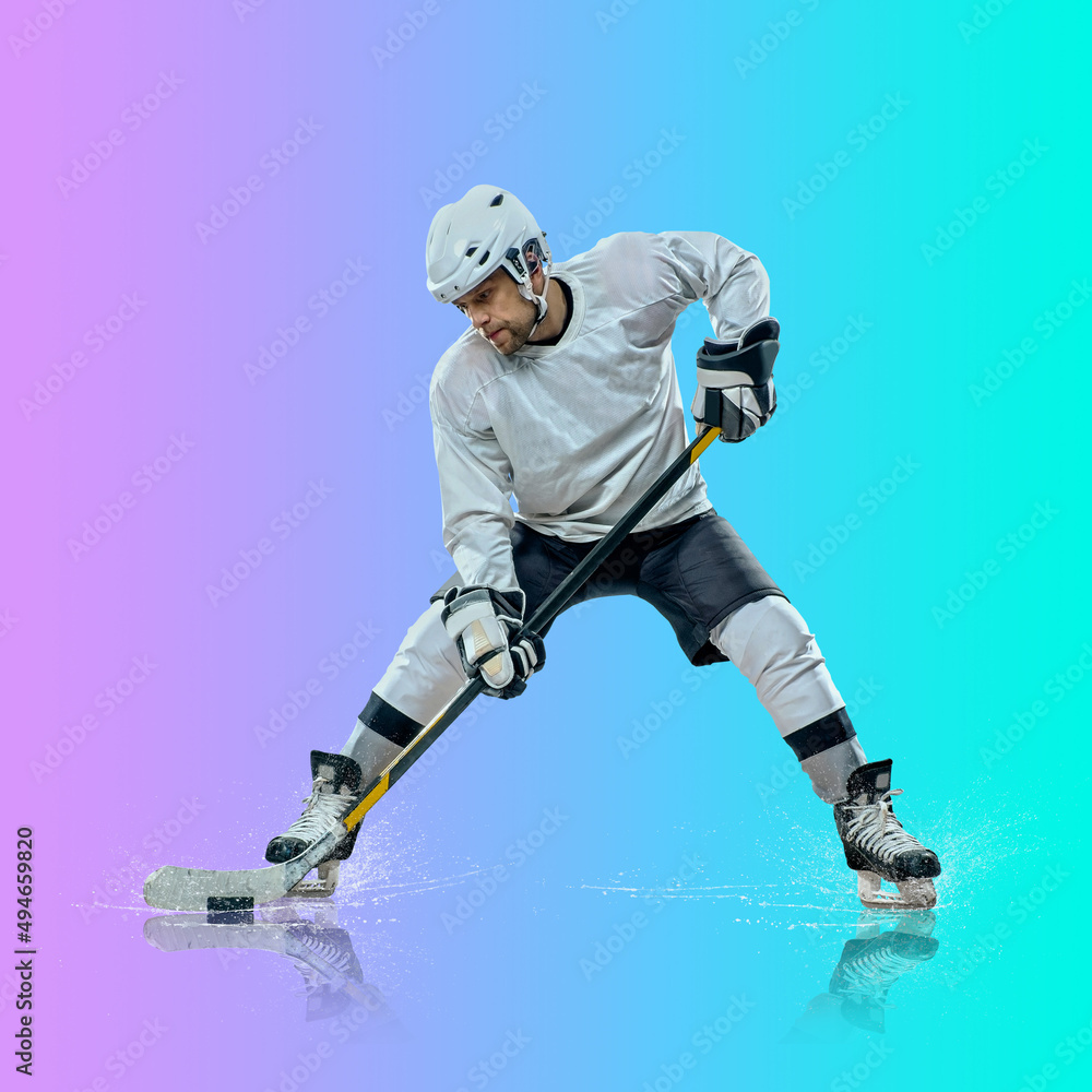 Naklejka premium Professional ice hockey player hitting puck for winning goal in action on gradient multicolored neon background. Concept of sport competition.