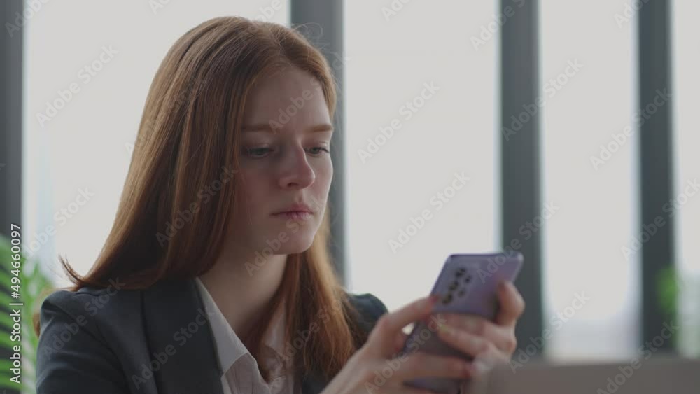 young businesswoman is reading news in mobile phone, portrait of serious and depressed lady in office young businesswoman is reading news in mobile phone, portrait of serious and depressed lady in office