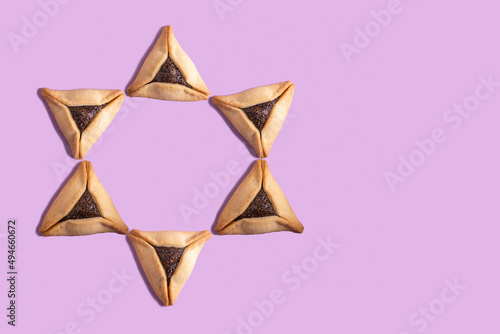 Hamantaschen (traditional cookies for Jewish holiday Purim) on purple background with copy space. photo