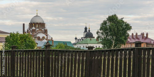 Behind an old wooden fence the Assumption Monastery in the town-island of Sviyazhsk. Cathedral of Our Lady Mother Of God Joy of All who sorrow and other buildings. photo